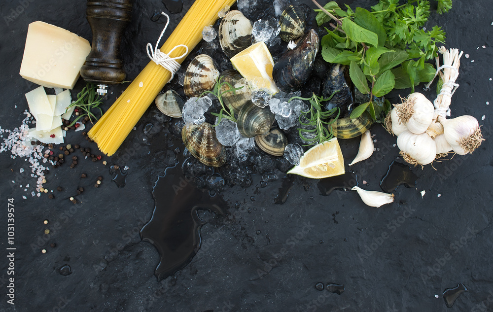 Ingredients for cooking Spaghetti vongole. Clams on chipped ice, raw pasta, Parmesan cheese, garlic,