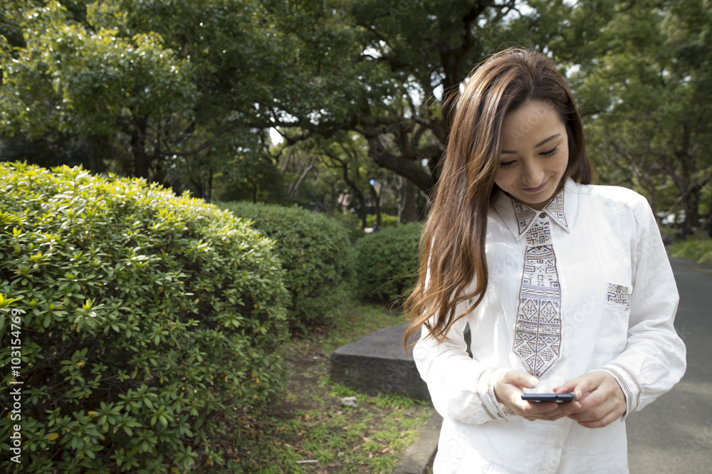 女性在公园里使用智能手机