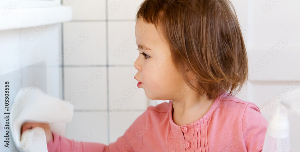 Toddler girl cleaning the kitchen