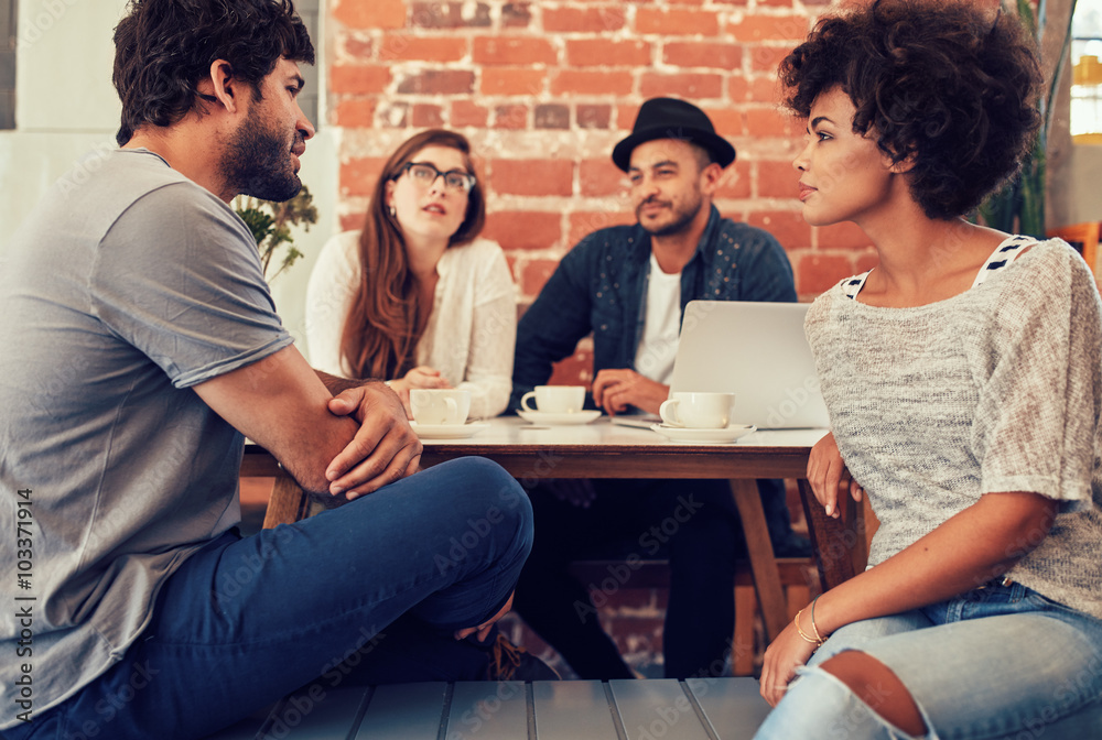 Young friends sitting and talking at a coffee shop