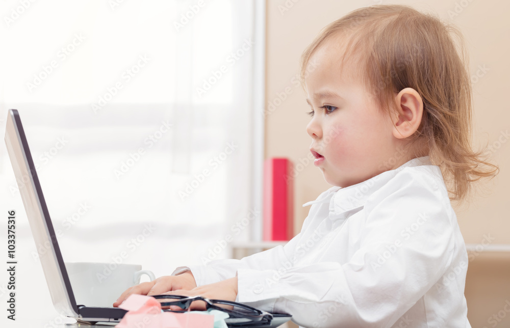 Happy toddler girl on her laptop