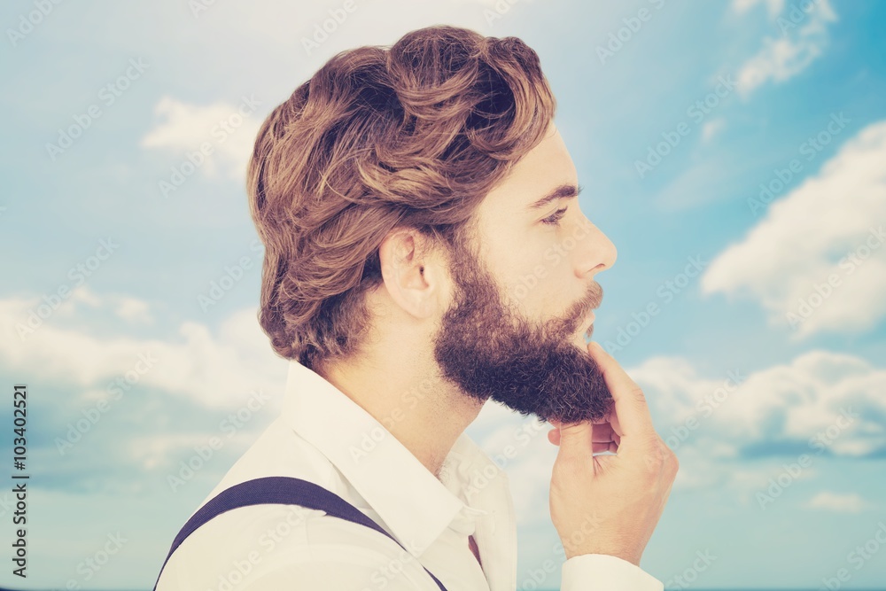 Composite image of profile view of hipster touching beard