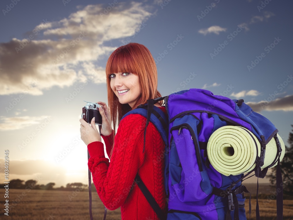 Composite image of smiling hipster woman with a travel bag