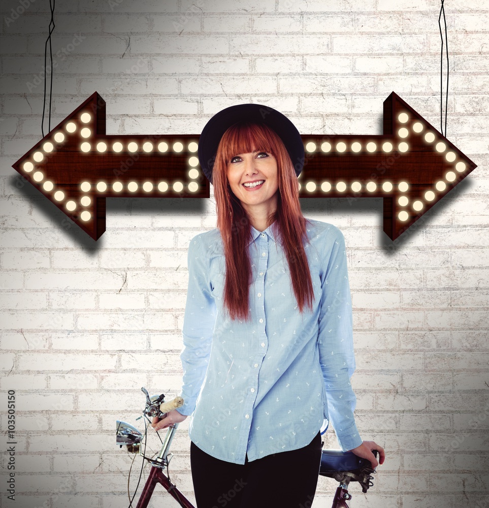 Composite image of smiling hipster woman leaning on a bike