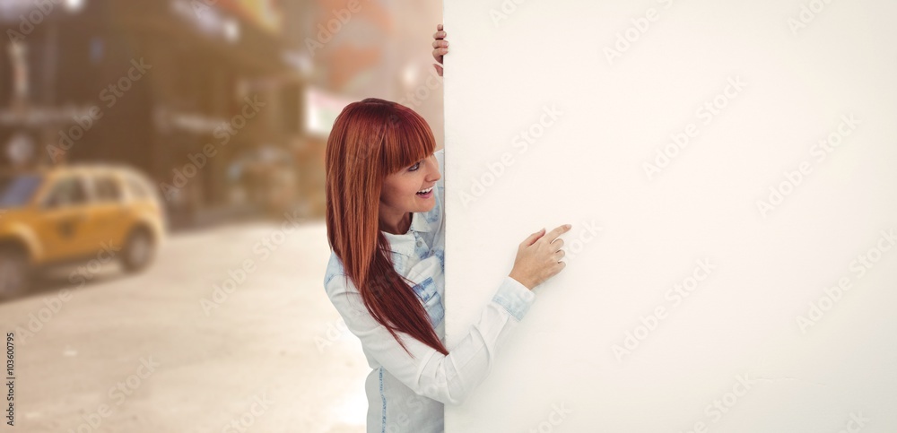 Composite image of smiling hipster woman behind a white card