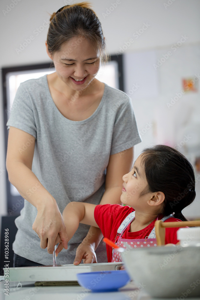 亚洲小可爱厨师和妈妈在厨房里做面包