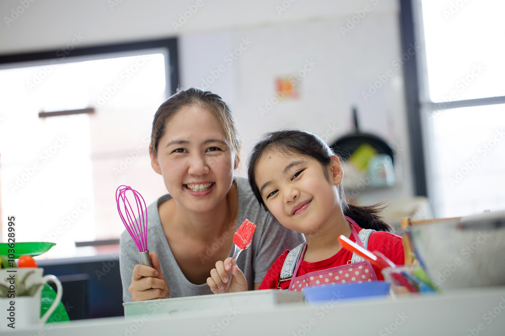 亚洲小可爱厨师和妈妈在厨房里做面包