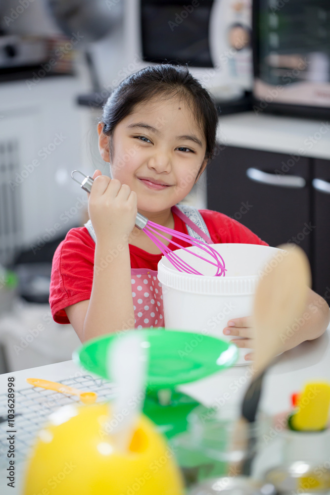 Little Asian cute chef cooking a bakery in kitchen