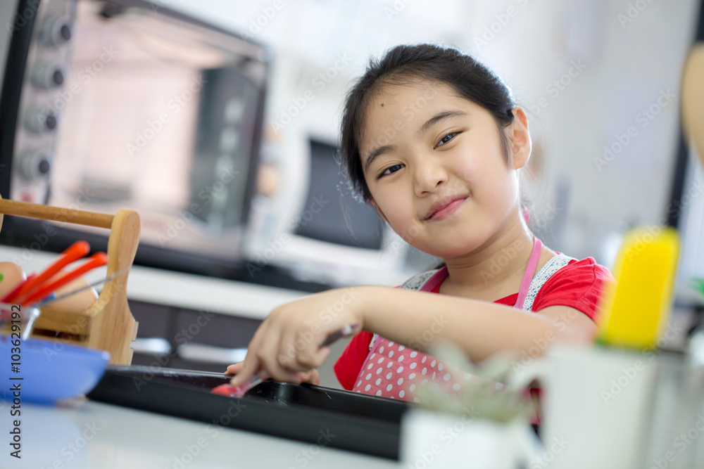 Little Asian cute chef cooking a bakery in kitchen