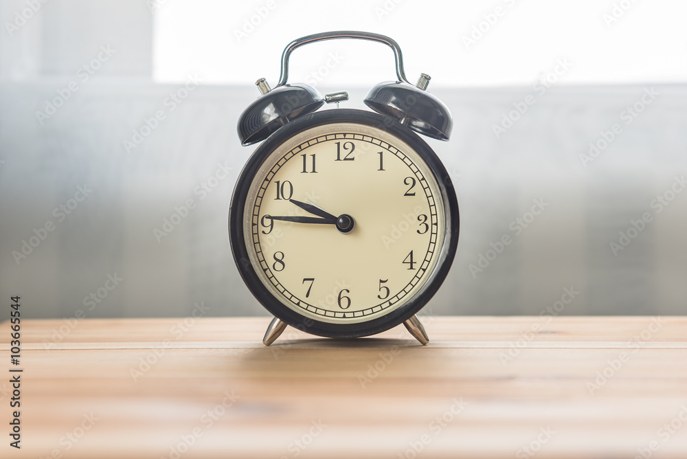 black alarm clock on wooden table