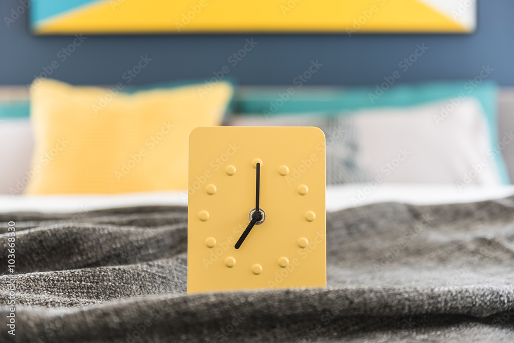 modern yellow alarm clock design on bed