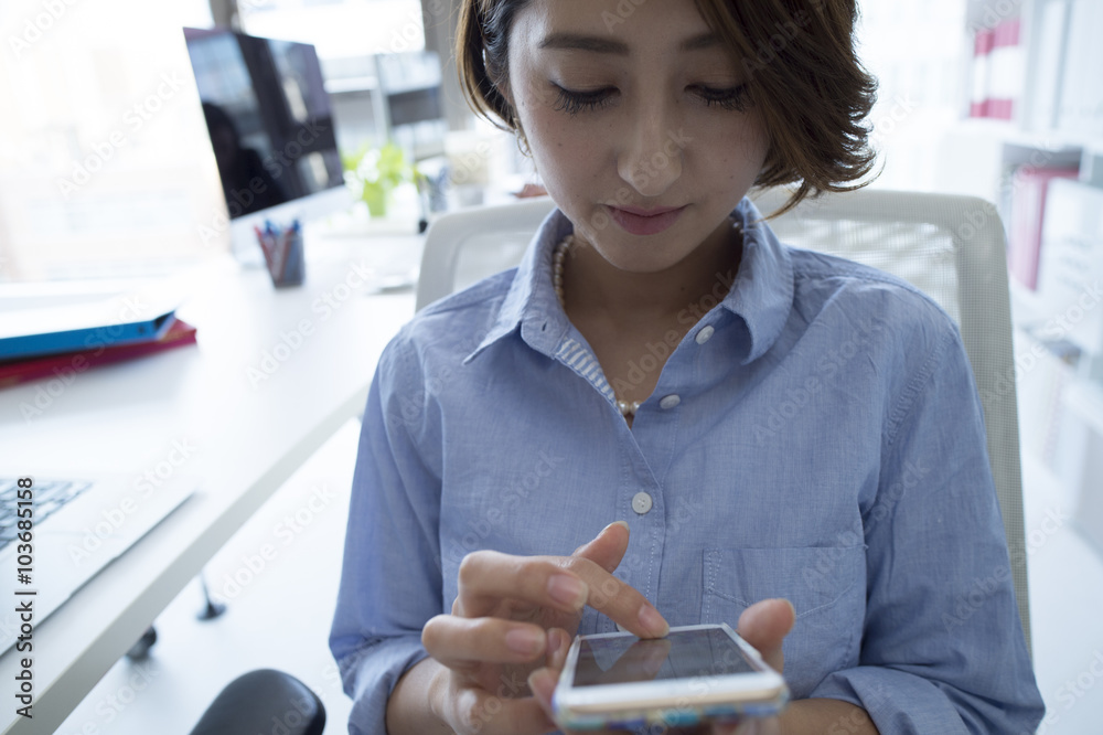 Business women are engrossed in a mobile game in the office