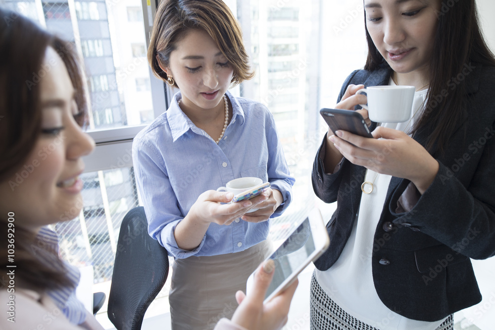 Business women looking at a smartphone to break time