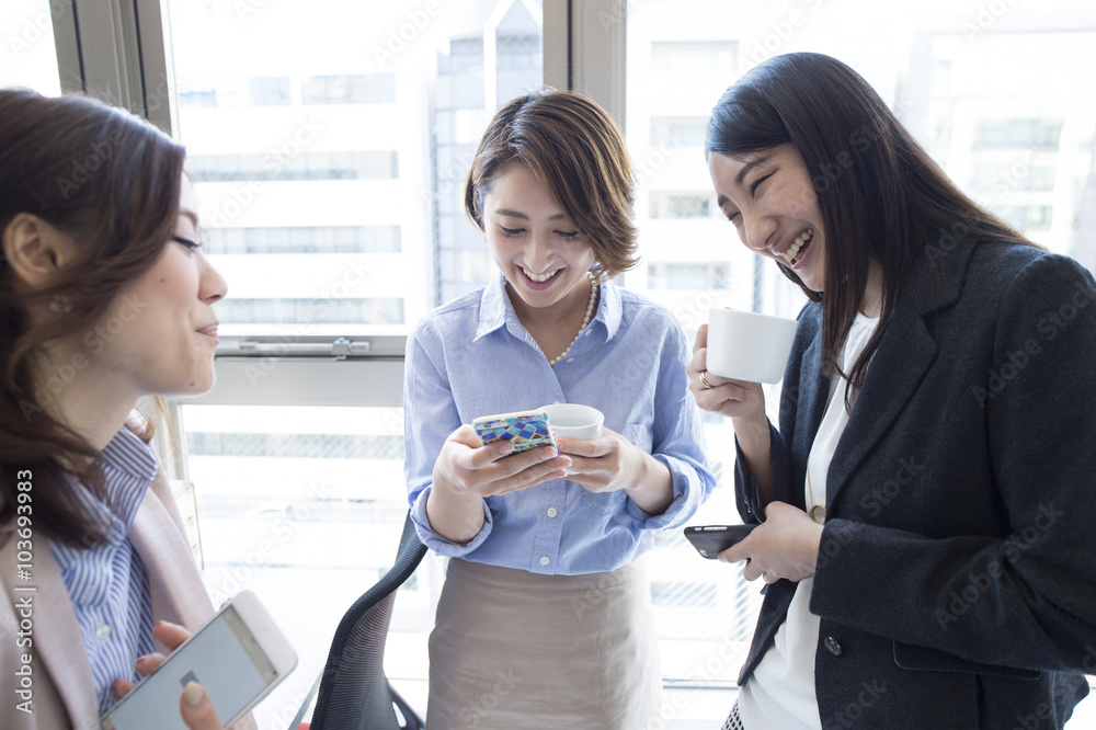 商务女性正在用智能手机聊天以消磨时间