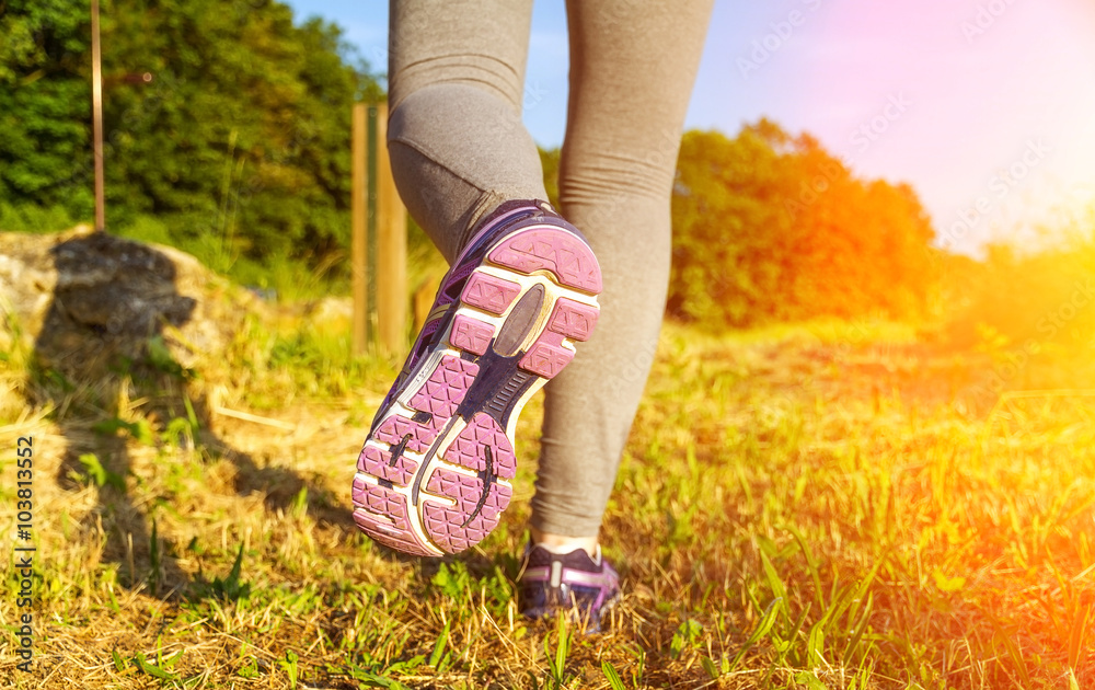 Woman running at sunset in a field