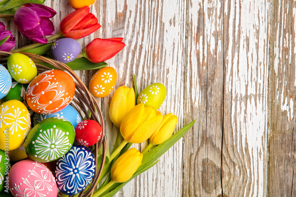 Easter eggs and tulips on wooden planks