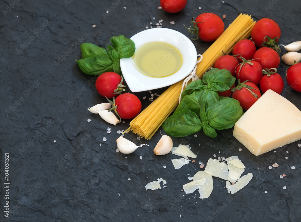 Ingredients for cooking pasta. Spaghetti, olive oil, garlic, Parmesan cheese, tomatoes and fresh bas