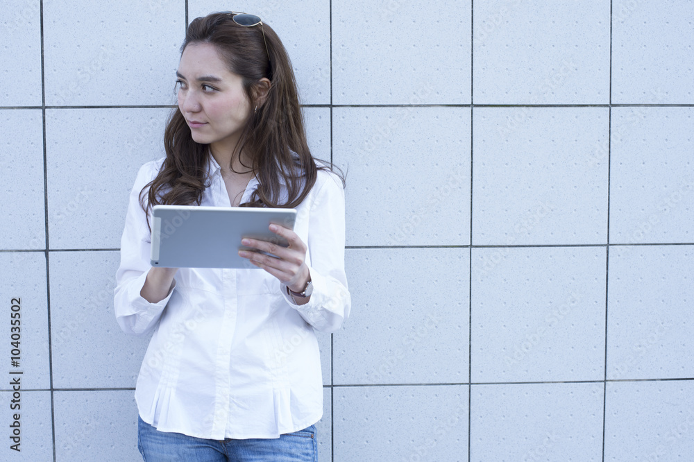 Young women are using electronic tablet outside