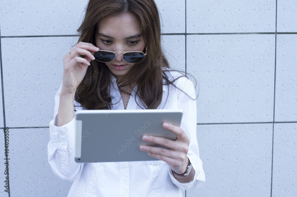 Young women have the electronic tablet outside