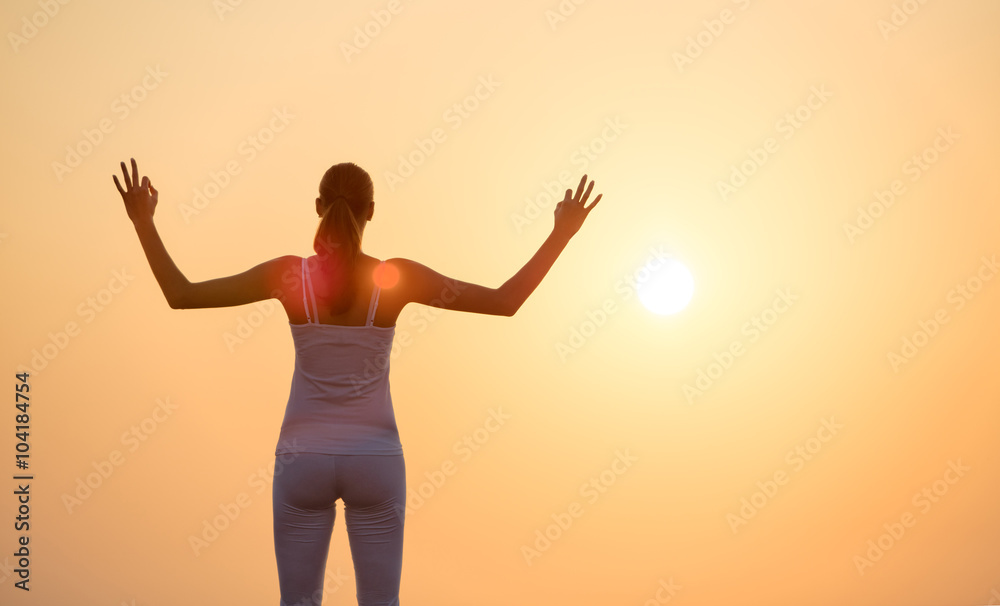 Young woman practising yoga in sunset