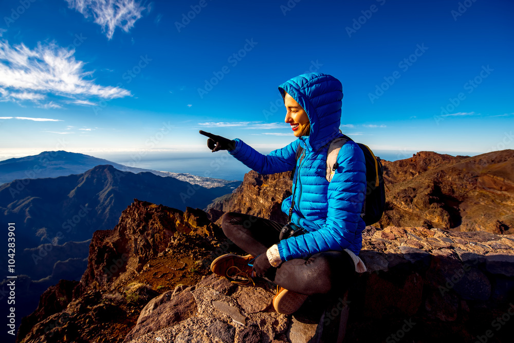 一名身穿蓝色夹克和背包的女子在La Palmas岛Andenes视点附近的山区旅行