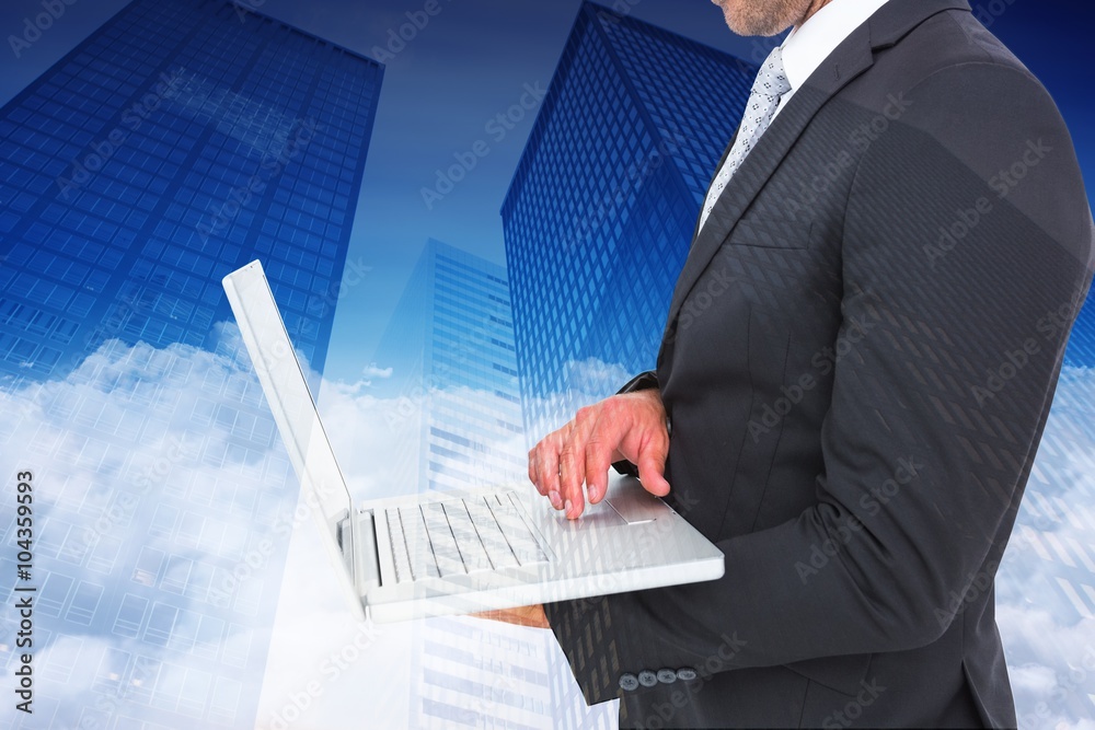 Composite image of businessman holding laptop