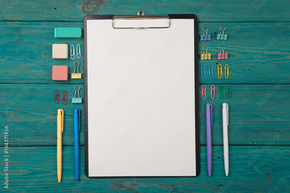 Blank sheet of paper and colorful office accessories