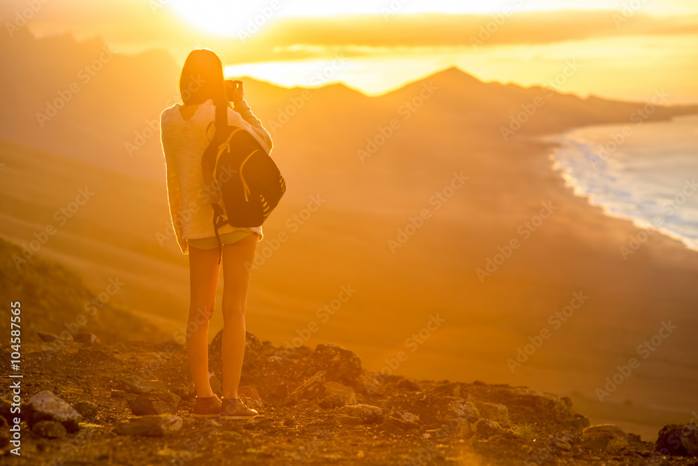 背着背包，带着相机的年轻女性旅行者用m拍摄美丽的科菲海岸线