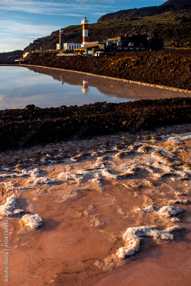 Volcanic pools on the salt manufacturing Fuencaliente with lighthouse and mountains on the backgroun