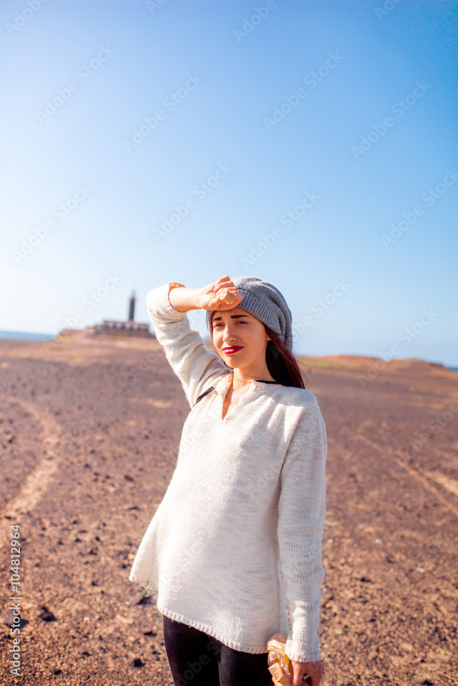 Young female traveler feeling tired standing on the deserted background