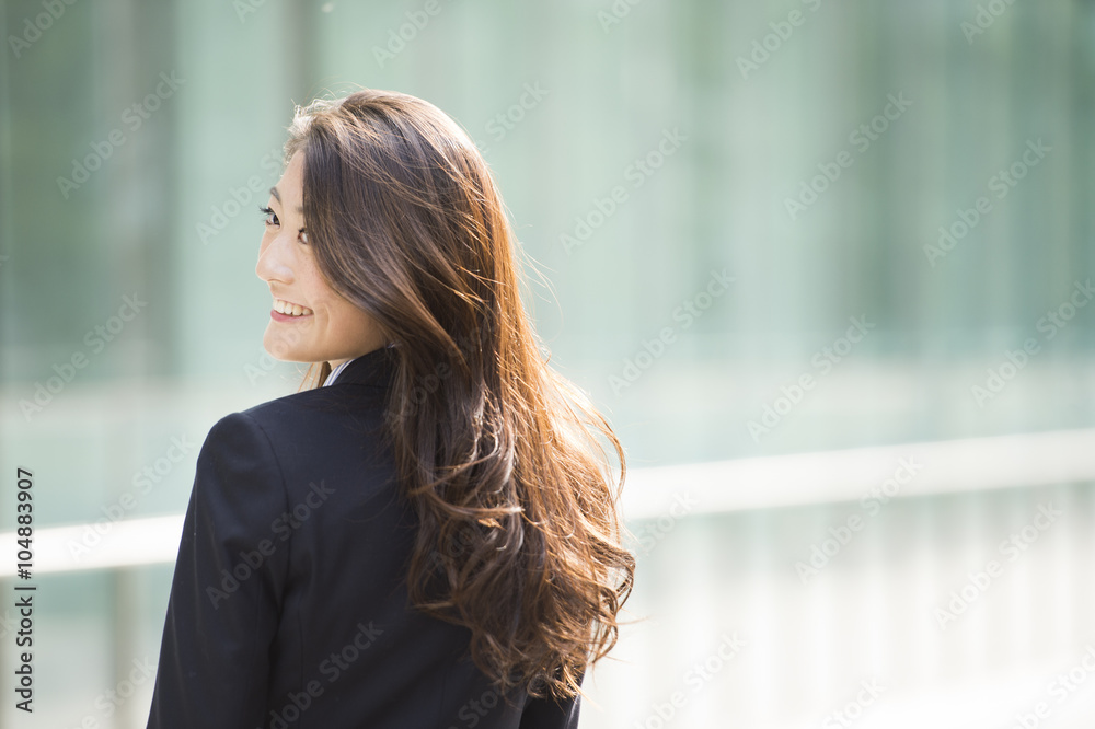 Woman wearing a business suit is turned around with a smile