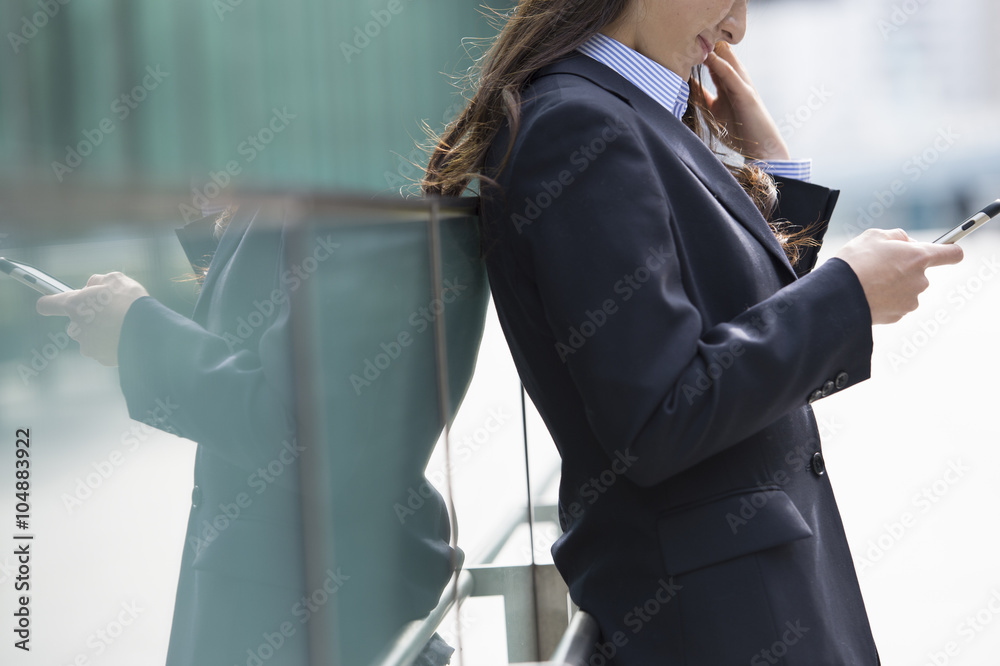 穿着西装的女人正在看智能手机里的信息