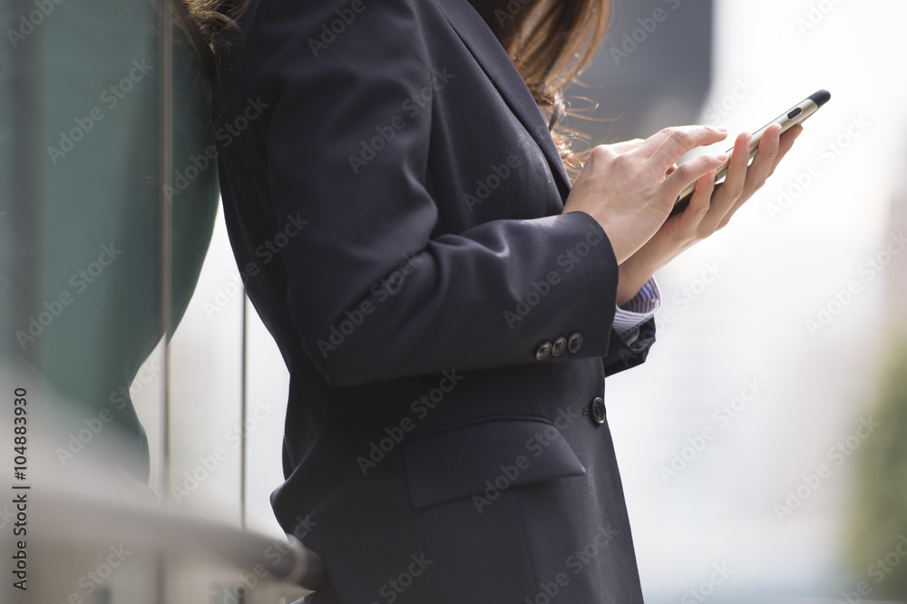 Woman wearing a business suit is looking at the information in the smartphone