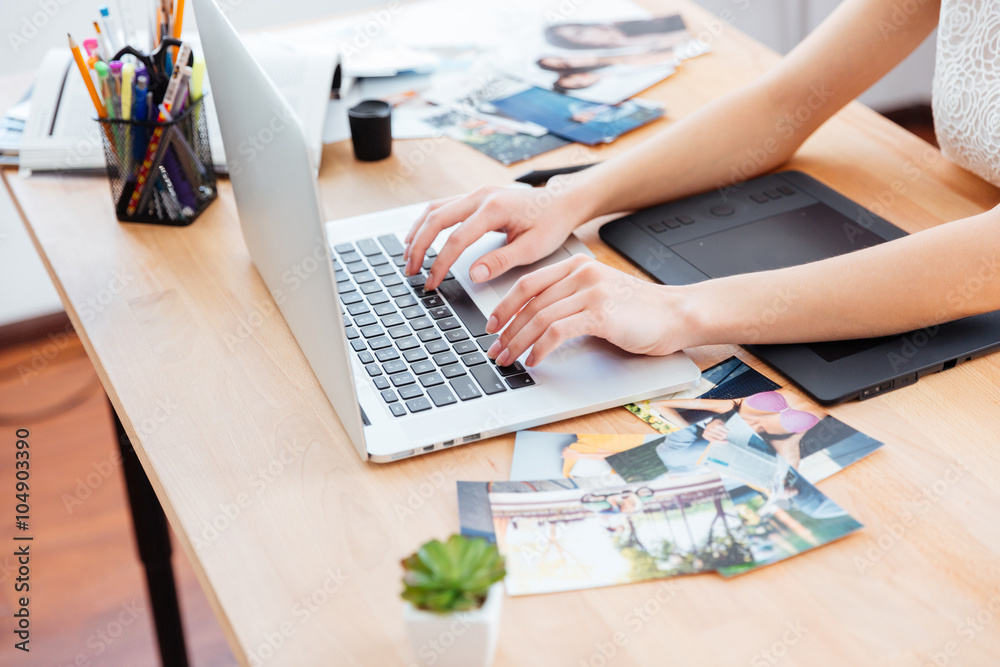 Woman photograper typing on laptop keyboard and using graphic tablet