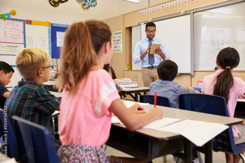 Teacher using tablet computer in an elementary school class