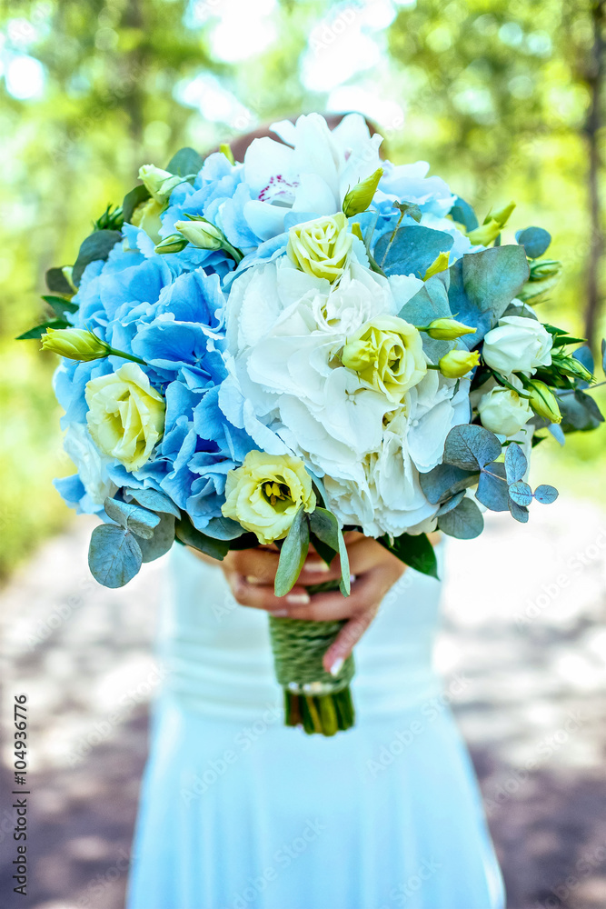 Woman holding blue and white flower as gift at sunny