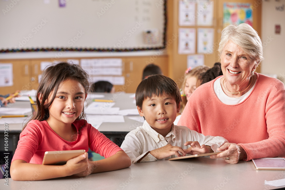 Senior teacher and elementary school pupils in classroom