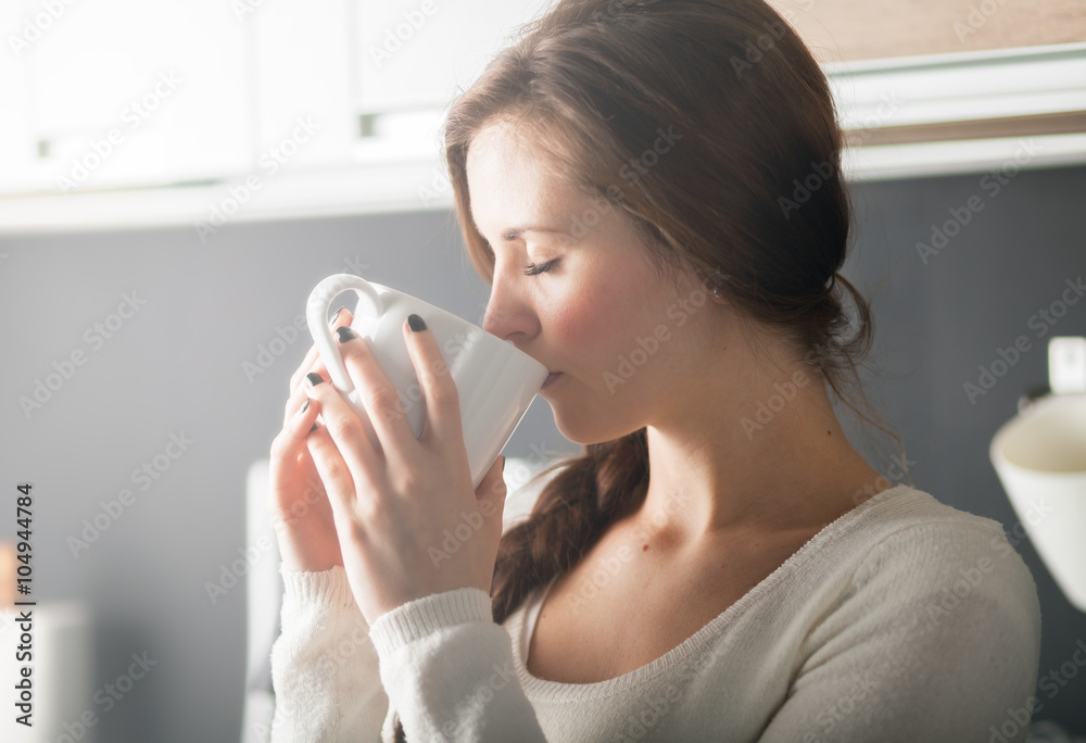 厨房里喝咖啡或茶的女人