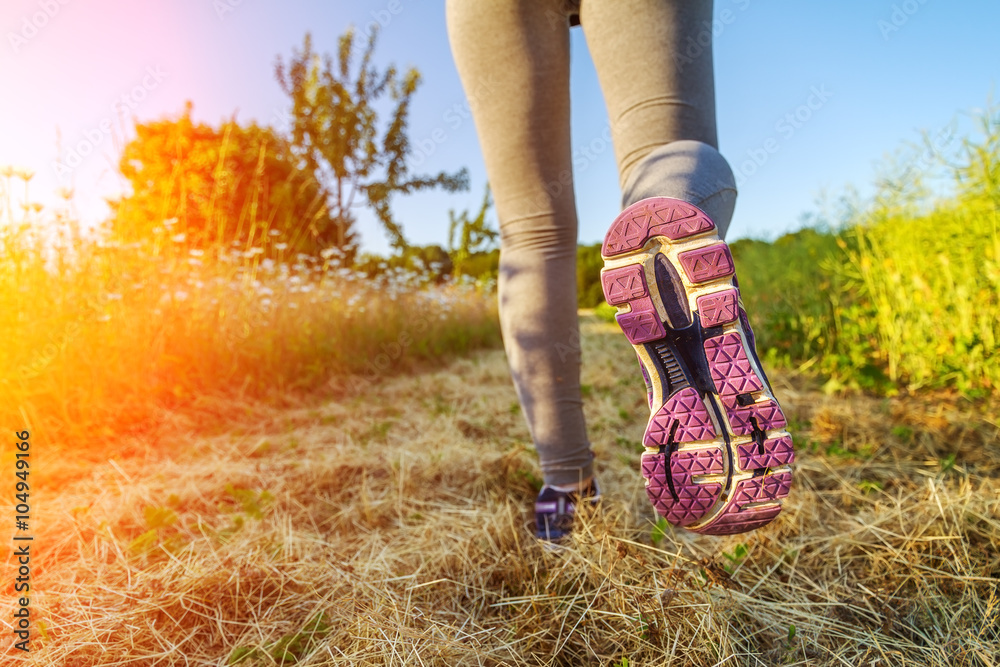 Woman running at sunset in a field