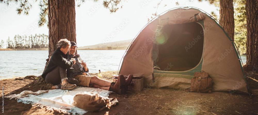 Mature couple enjoying a glass of wine at their campsite