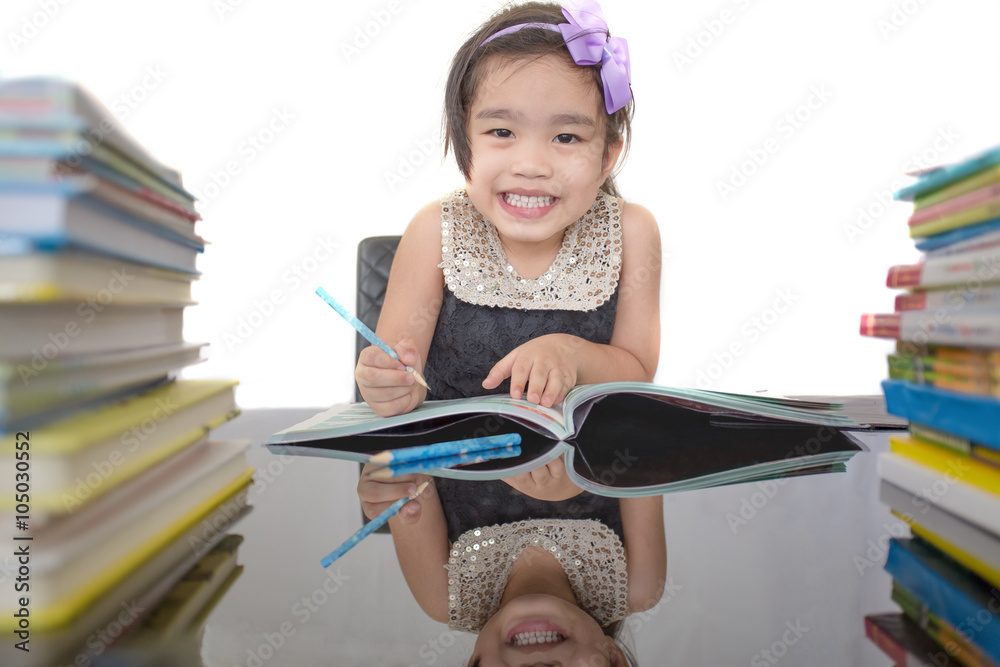 happy schoolgirl works on her homework, write something in her notepad on white background