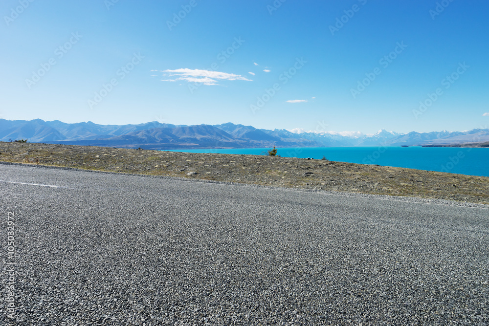 asphalt road near lake in summer day in New Zealand