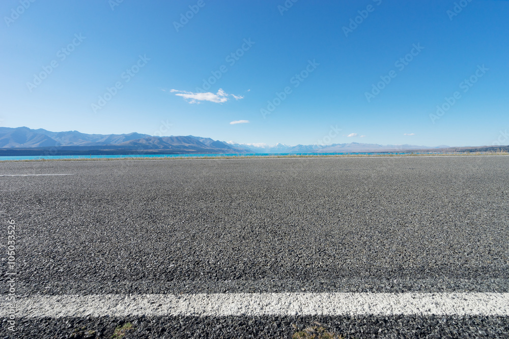 asphalt road near lake in summer day in New Zealand