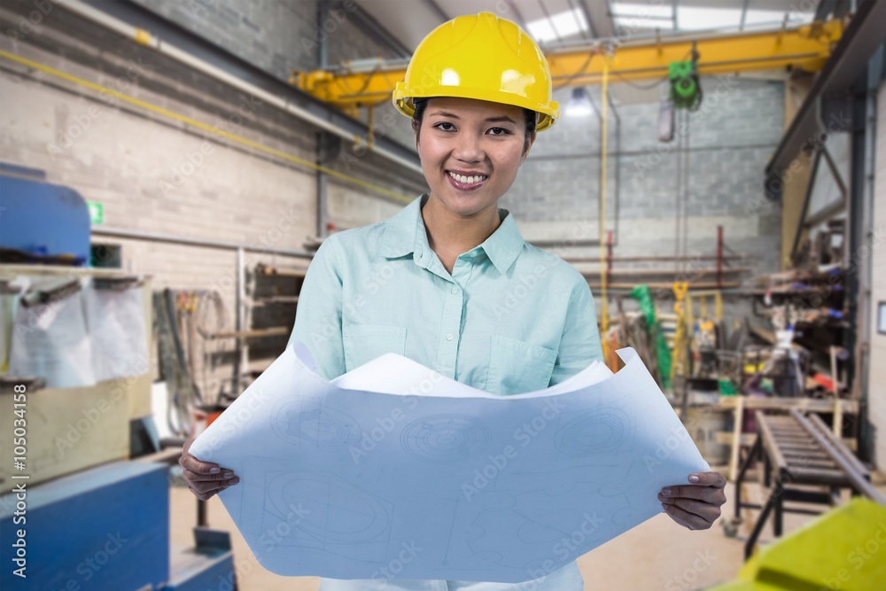 Composite image of architect reading a plan with yellow helmet