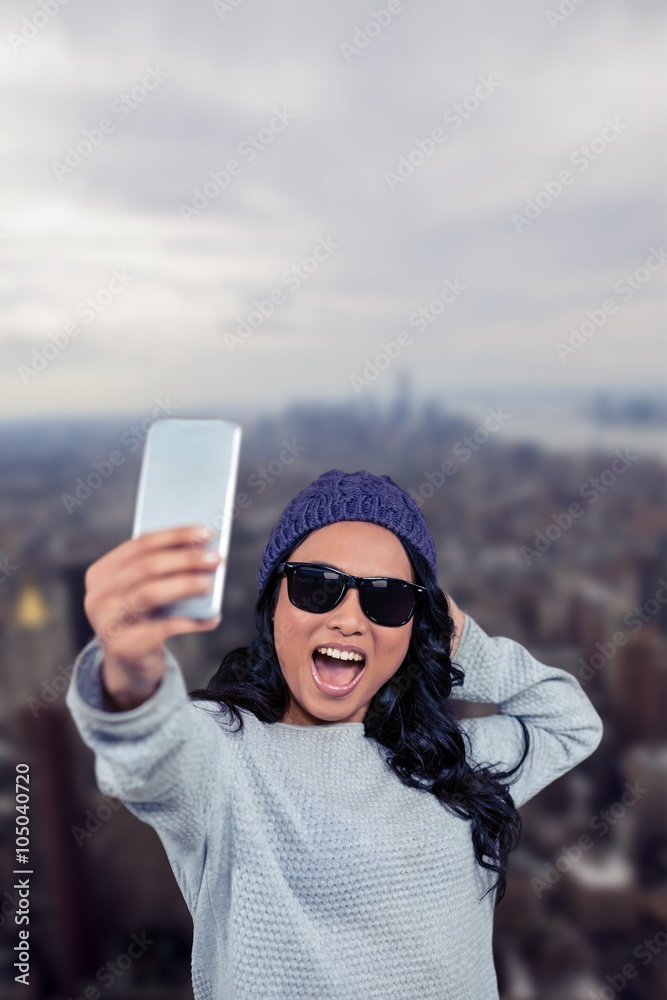 Composite image of asian woman taking selfie