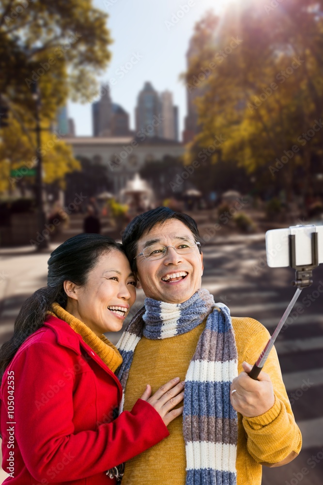 Composite image of older asian couple on balcony taking selfie