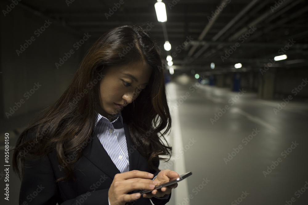 在停车场使用智能手机的女性