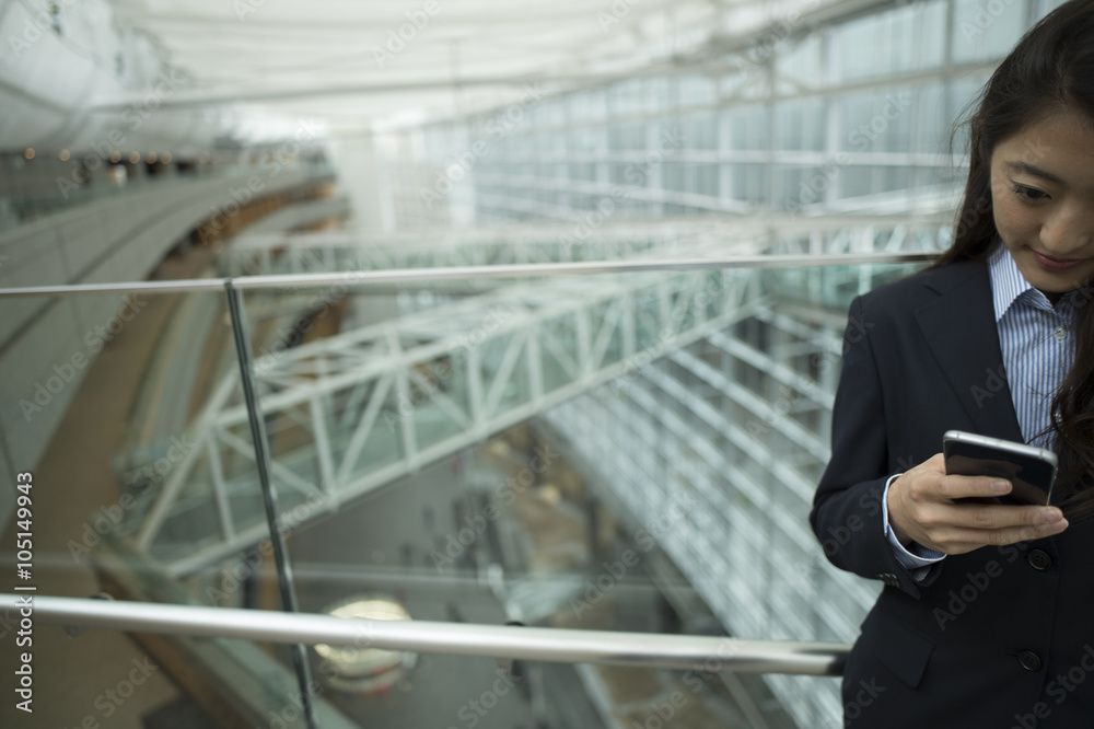 Woman looking at the smartphone in a modern office