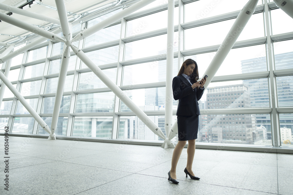 女人在现代建筑里看智能手机