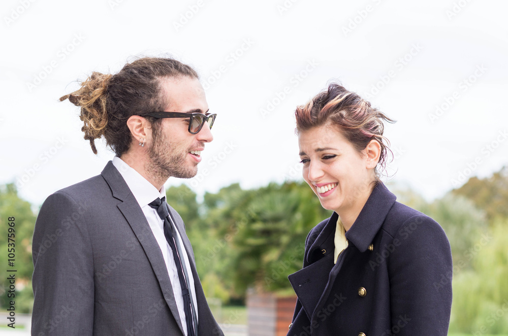 Date between a businessman and a businesswoman - the woman is laughing out loud while the man is tal